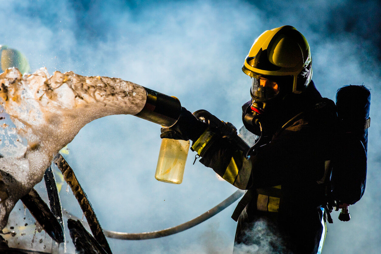 Firefighter applying foam